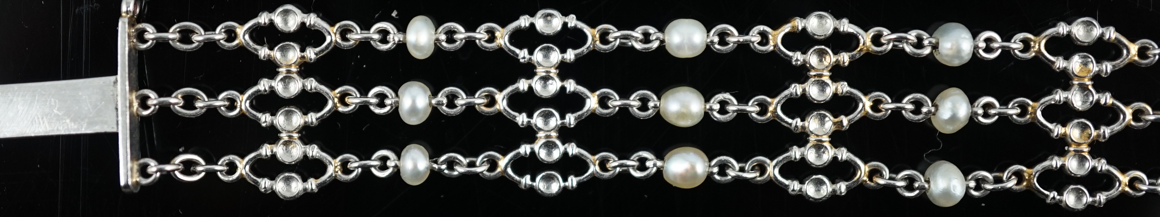 An early to mid 20th century white gold and seed pearl set three row chain link bracelet